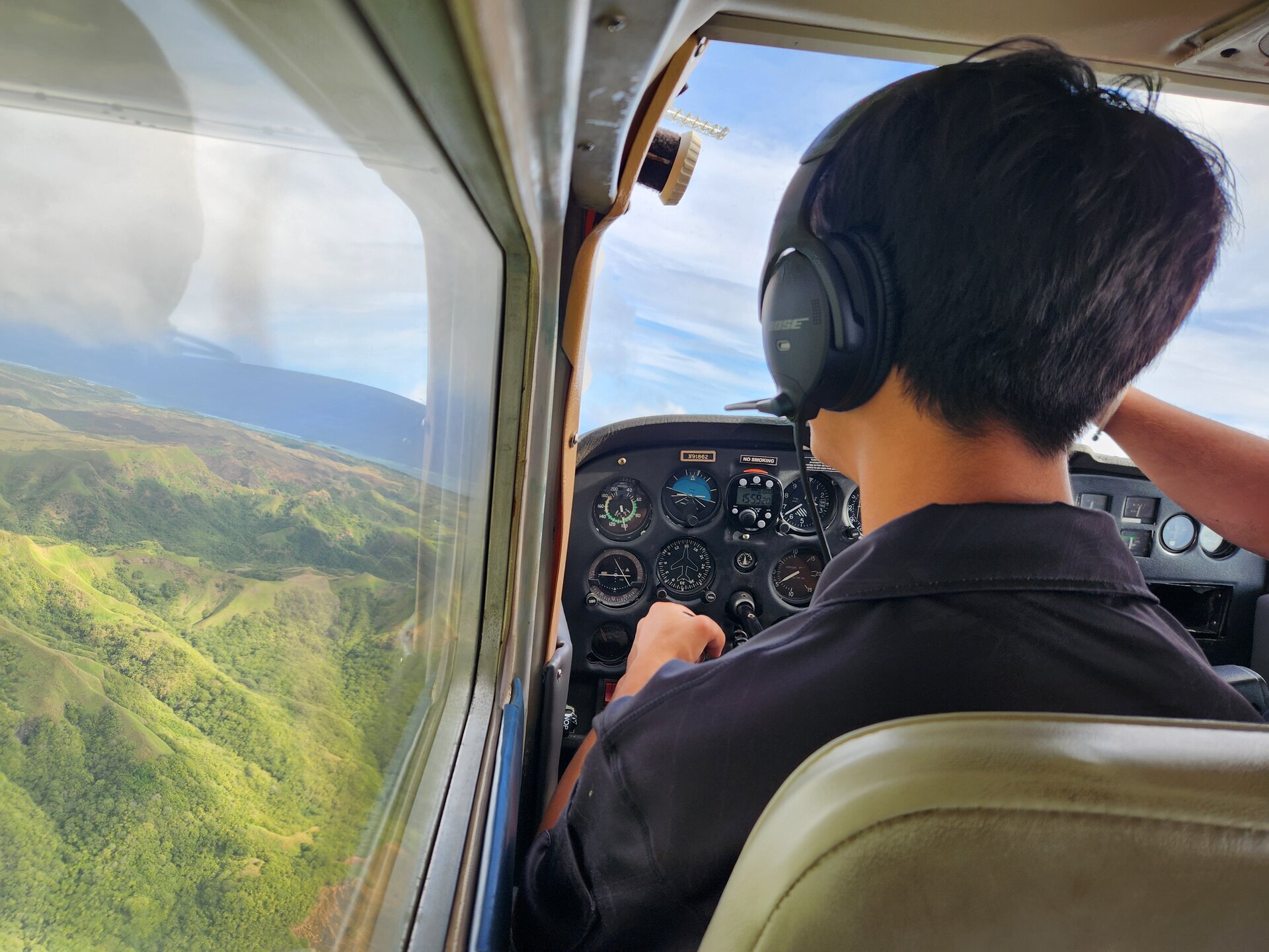 Jaden at controls flying over green mountains