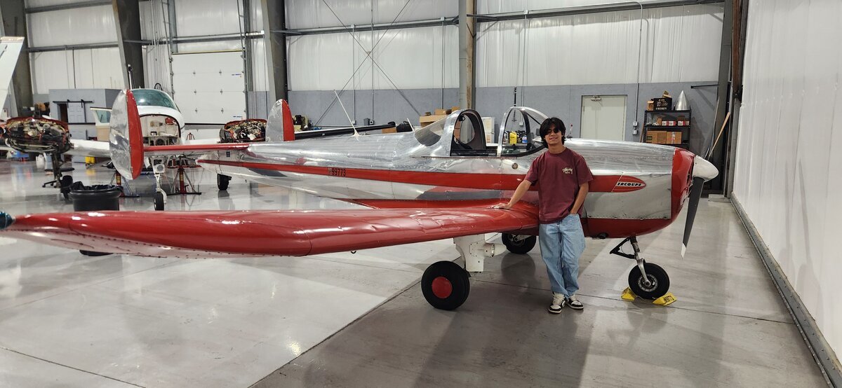 Jaden in hangar with red aircraft